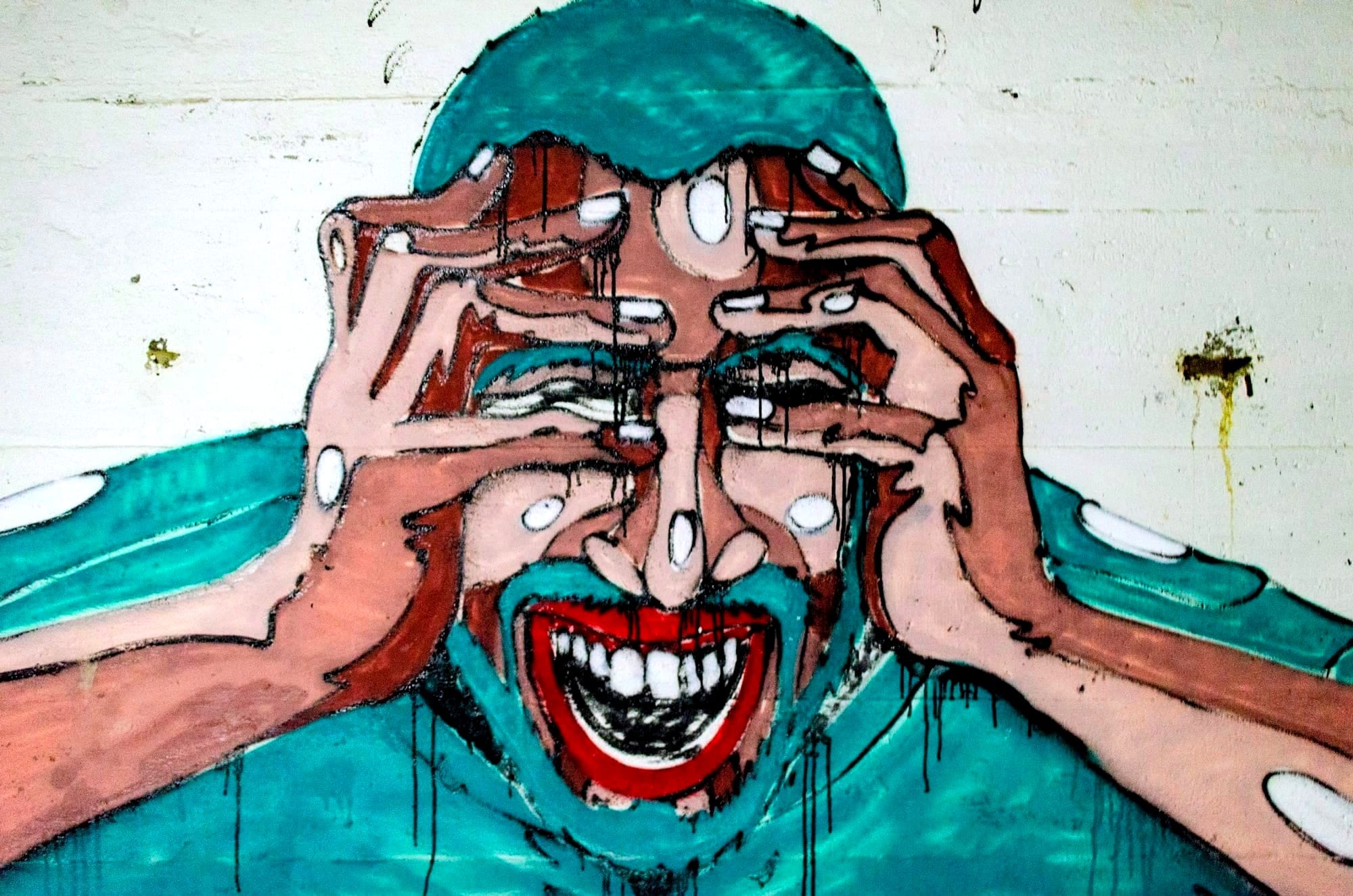A painting of a laughing man on the brink of tears.