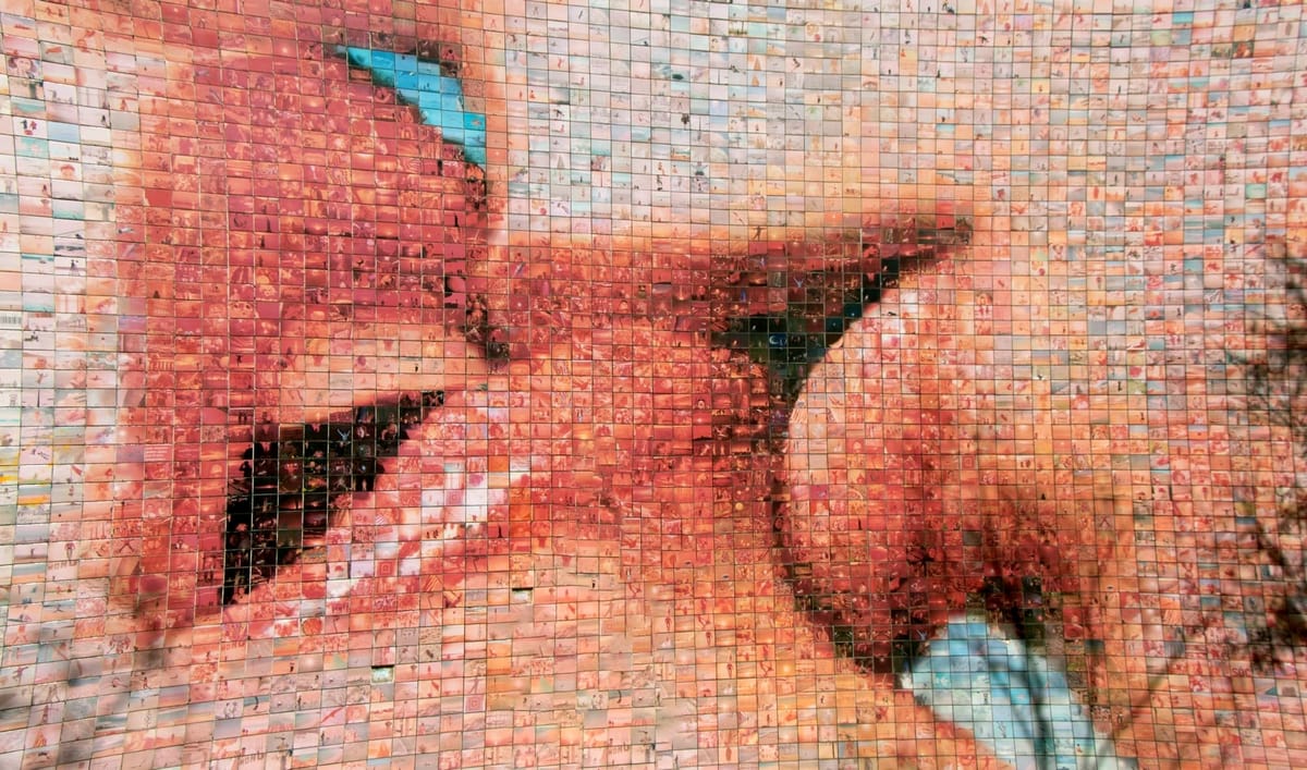 a close-up of someone gently biting another's lips, with the image made up of individual tiles