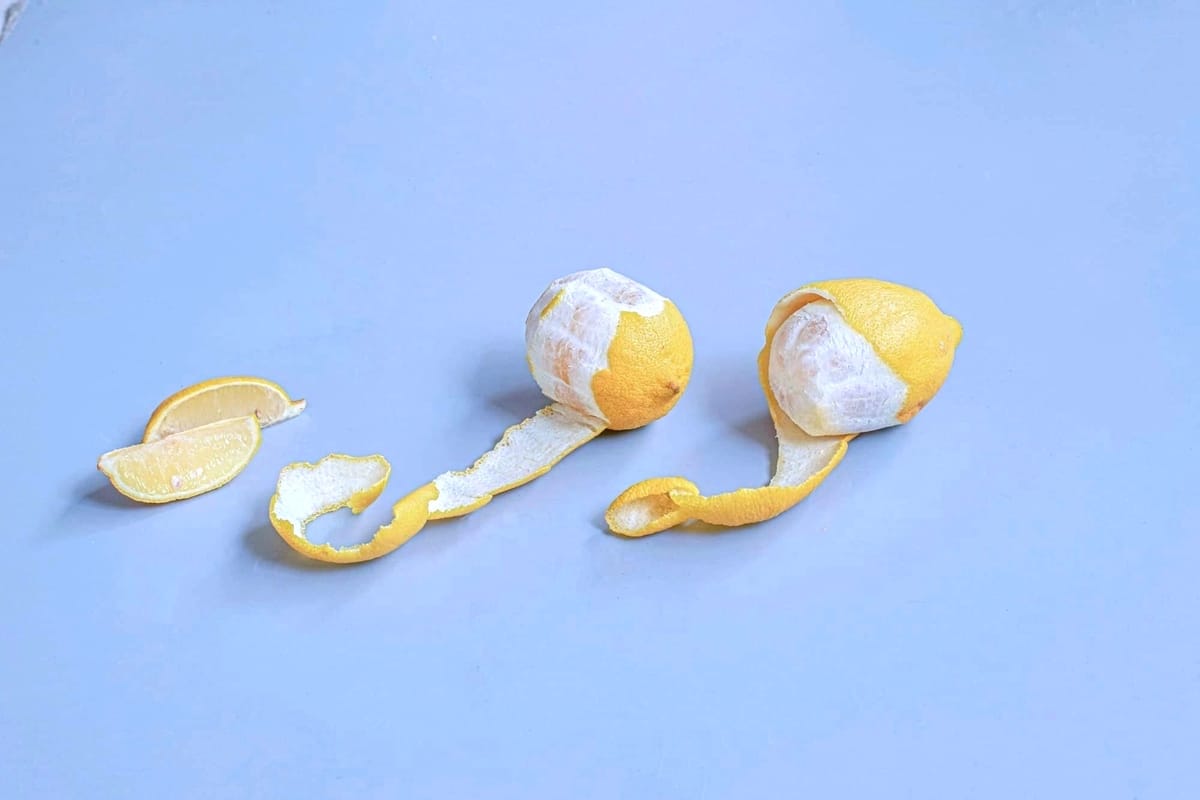 Lemon halves and peels on a light blue surface.