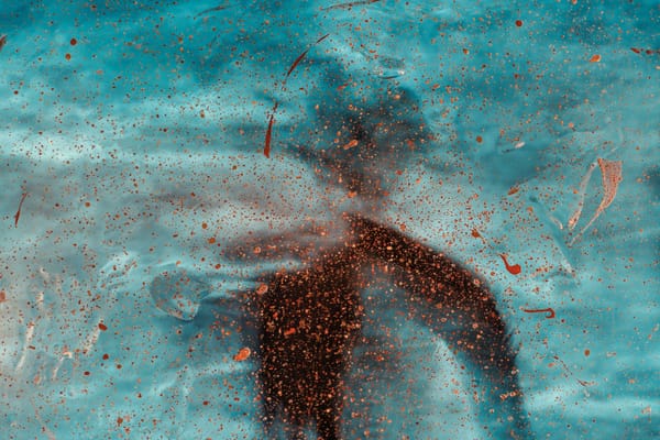 An abstract silhouette of a man standing in the snow or rain with his back to the camera.