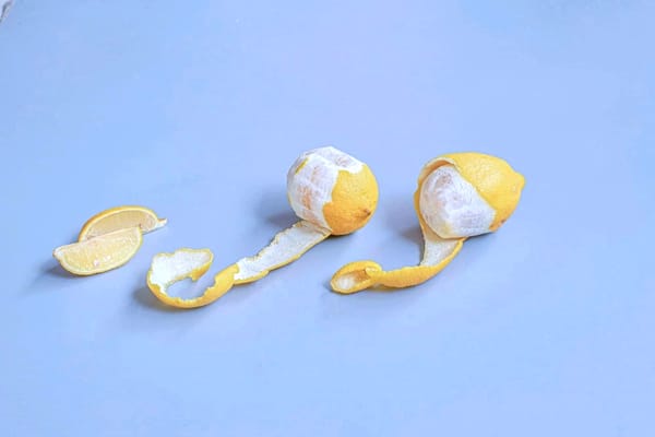 Lemon halves and peels on a light blue surface.